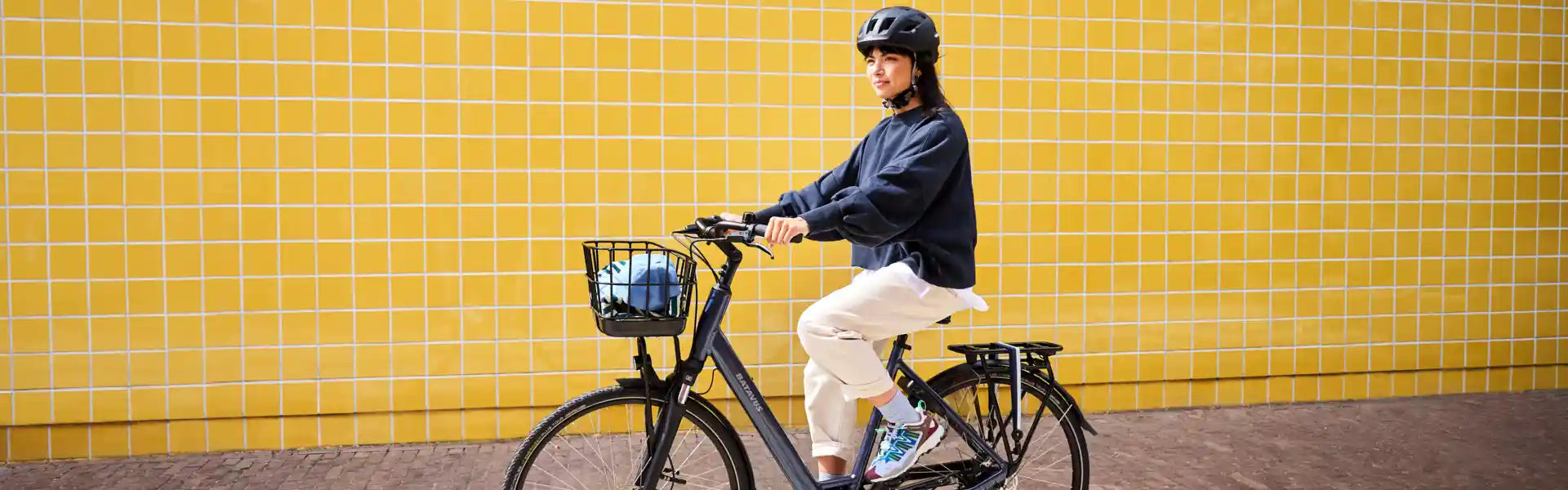 Kvinna cyklar med en Batavus elcykel i staden