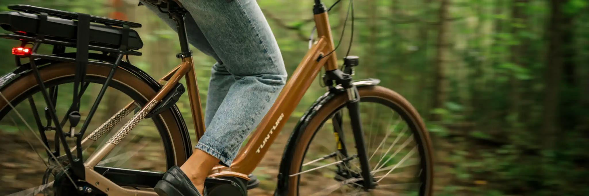 En kvinna cyklar på en brun elcykel